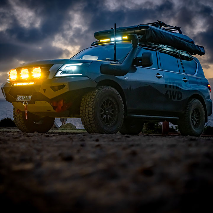 Modified four-wheel drive photographed under a dramatic night sky