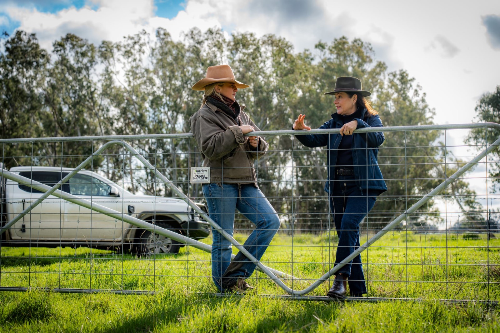 Two women talking over a farm gate